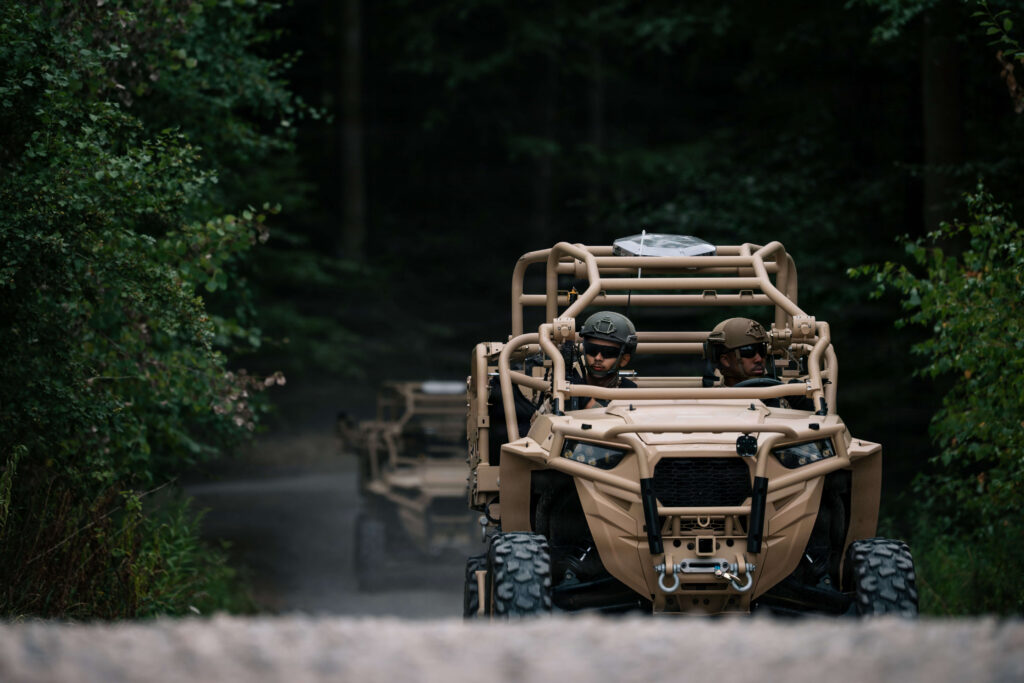 U.S. Air Force personnel driving a Polaris MRZR light tactical vehicle during a simulated patrol